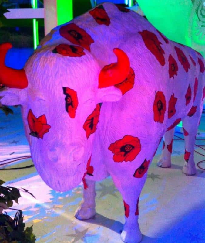 Bisons dans "Je t'aime Pologne" 4 Rzeźba byka pomalowana na biało, z czerwonymi makami i czerwonymi rogami.