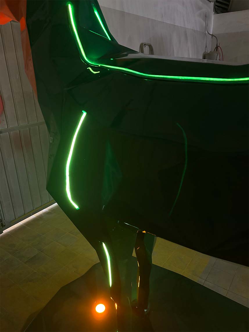Cerfs Jägermeister avec Éclairage LED 5 Zdjęcie przedstawia ciemny obiekt o błyszczącej powierzchni z podświetleniami w kolorze zielonym, znajdujący się w zamkniętym pomieszczeniu.