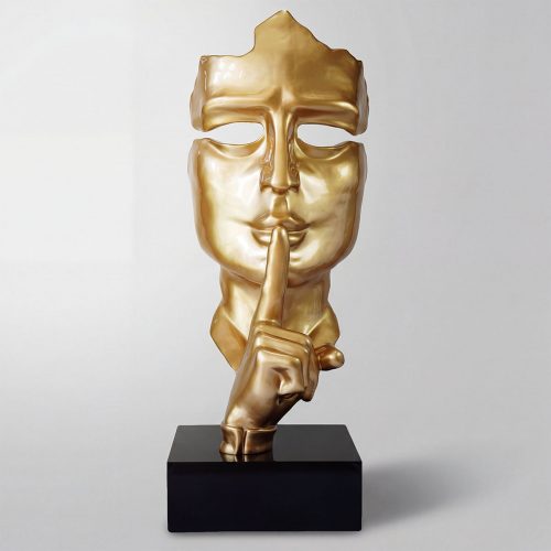 sculpture visage doré en fibre de verre stylisée, main au doigt sur les lèvres, décoration intérieure ou publicité
