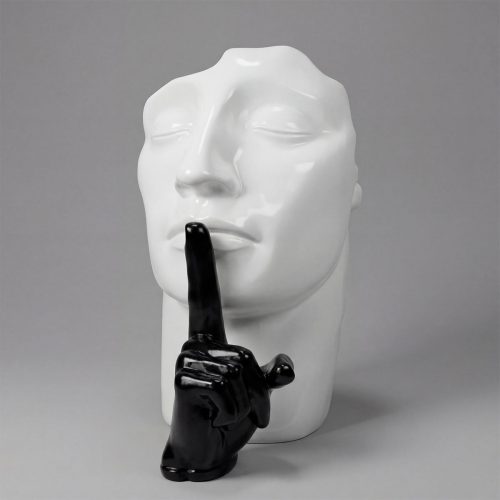 sculpture tête blanche en fibre de verre avec main noire brillante faisant signe silence, style contemporain décor intérieur événement
