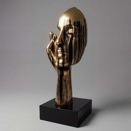 sculpture tête stylisée en fibre de verre dorée avec motifs de coulures noires, design artistique pour décoration ou événement