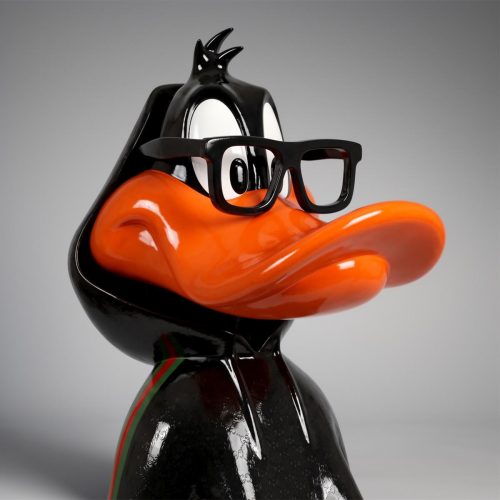 figure Daffy Duck en fibre de verre, style cartoon réaliste noir et orange, tenue streetwear Gucci, déco vitrine ou événement